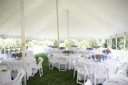 Wedding Reception with White Tablecloths and Colorful Centerpieces Outside Under a Large White Tent