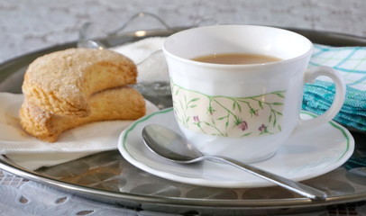 Biscuits and tea with milk on a tray