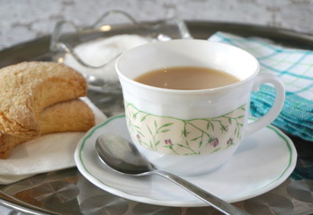 Biscuits and tea with milk on a tray