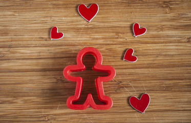 man figure presenting and showing heart on wooden background
