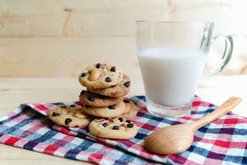 chocolate chip cookies and milk with wooden background