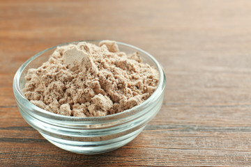 Superfood powder in bowl on wooden table