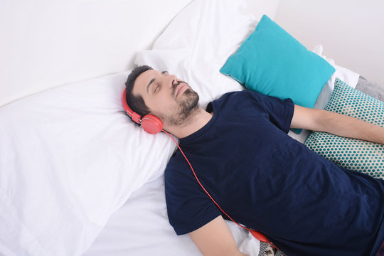 Man listening to music in bed.