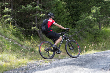 Urecognisable mountainbiker on a gravel road