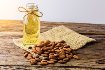 Peeled almonds with bowl and Bottle of almond oil on rustic wooden