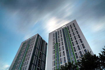 Obraz premium two buildings as two towers amid flying clouds