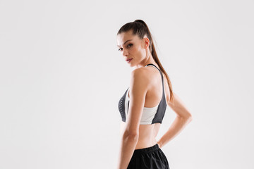 Obraz premium Side view portrait of a pretty fitness woman in sportswear