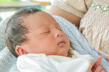 Baby sleeps on mother's chest.