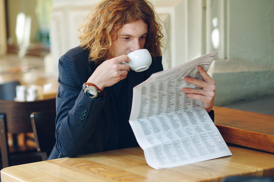 Hipster man drinking coffee while reading