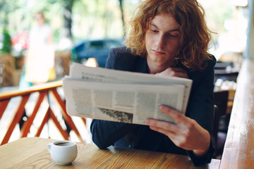 Young man reading a newspaper 