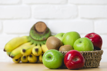 Fresh kiwi, apples and bananas on wooden background