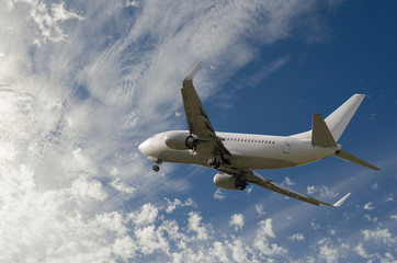 Naklejka na ściany i meble Airplane flying in sky with l clouds