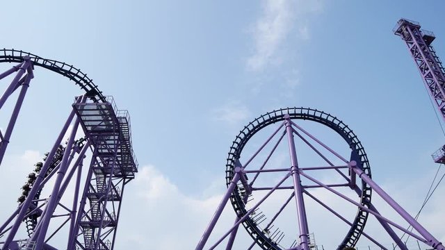 roller coaster, a trolley with people riding on the loops of a roller coaster 4k.