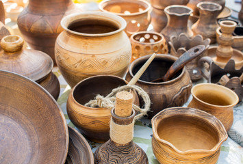 Fototapeta na wymiar Clay dishes. Traditional rustic crockery. Brown and beige pottery plates, jugs, vases and pots
