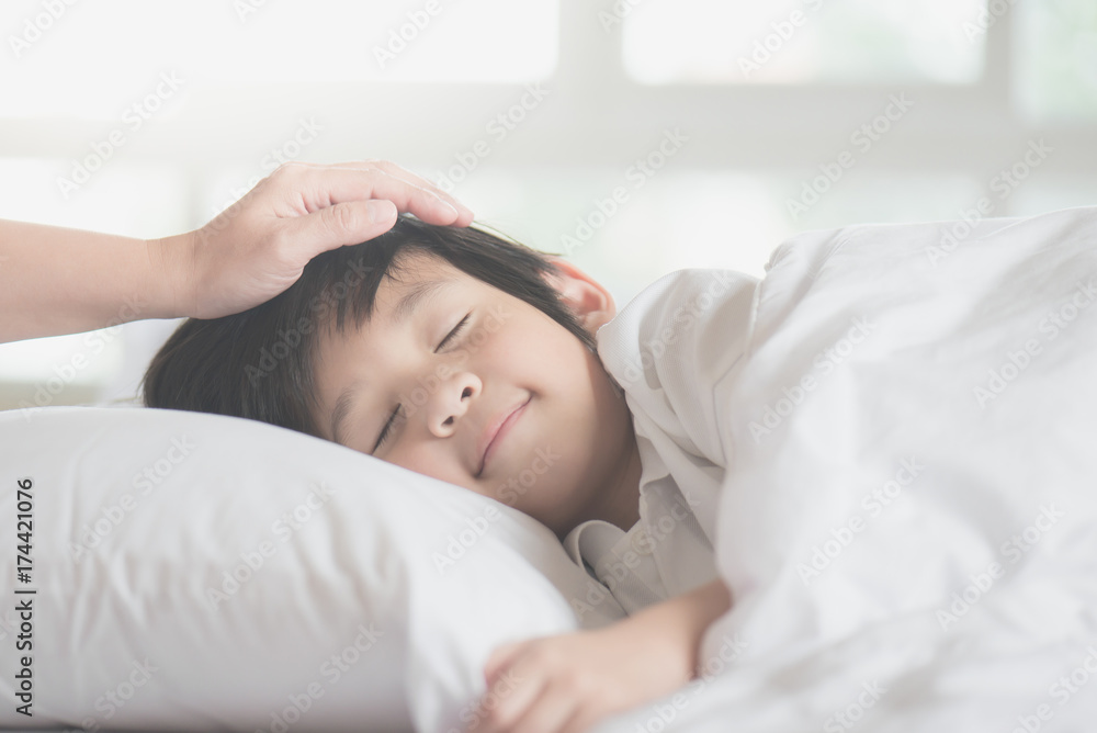 Wall mural Asian child sleeping on white bed