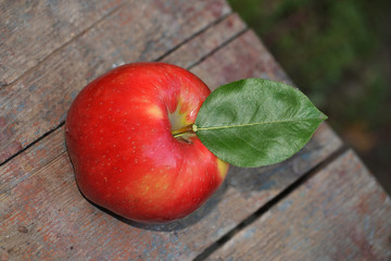 Red apple on a wooden surface.