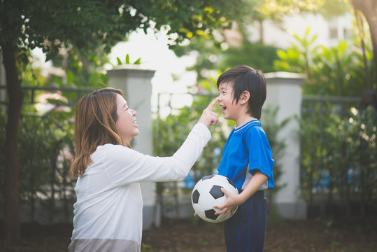 Asian mother and son Playing Soccer