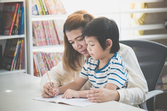 Asian mother helping her son doing homework