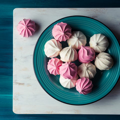 Pastel color pink and white meringue on green background