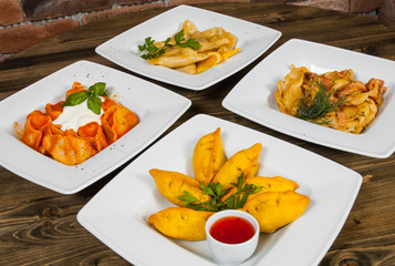 Set of different dumplings and ravioli on a wooden table