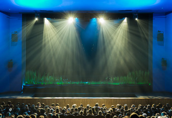 The stage before the show. The audience in the hall. The spotlight on stage. Theatre.