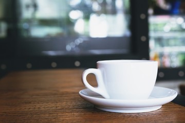 The coffee cup is placed on the table wooden in the coffee shop style loft modern.