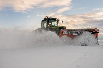 Traktor mit Schneepflug bei der Schneeräumung in Österreich. Landwirtschaftlich ausgerichtete...