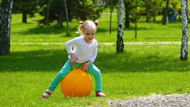 Little girl is jumping on the ball
