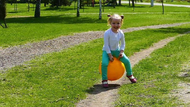 Little girl is jumping on the ball