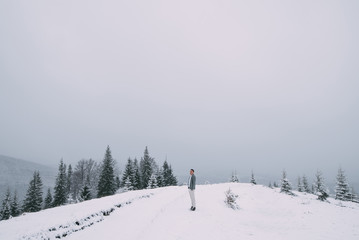 Outdoor portrait of handsome man in coat and scurf.