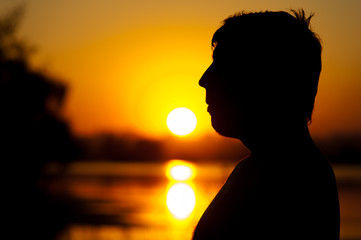 Silhouette of relaxed man at river or lake water