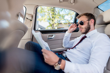 businessman with newspaper in car
