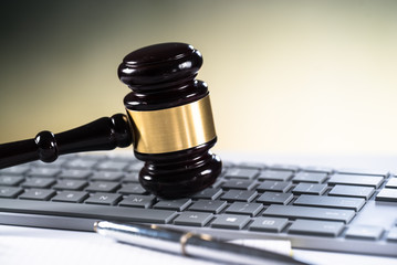 Wooden gavel on laptop keyboard. auction, online, law, technology, justice concept