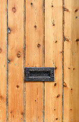 Old striped wooden door with metal letterbox