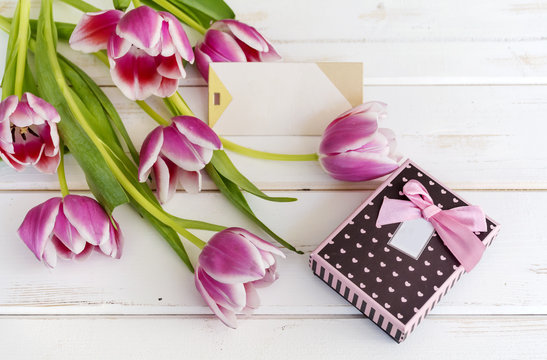 tulips flower on wooden background  with empty  card and gift box