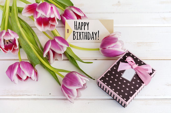 tulips flower on wooden background  with happy birthday card and gift box