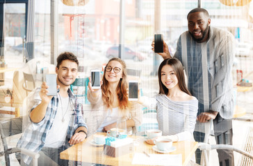 Successful colleagues showing mobile phones