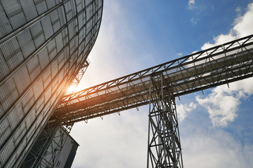 Fragment of metal grain elevator in facility with silos.