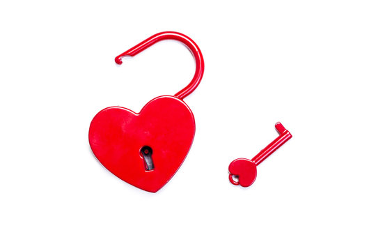 öppet hjärtformat hänglås med nyckel bredvid isolerat mot vitt