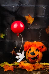 Foto op Plexiglas Scary red hair clown made from pumpkin, holding red balloon. Spooky dark Halloween background. Greeting card, space for text © happy_lark
