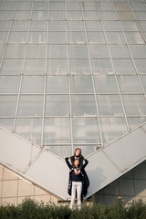Mom and daughter against the glass architecture