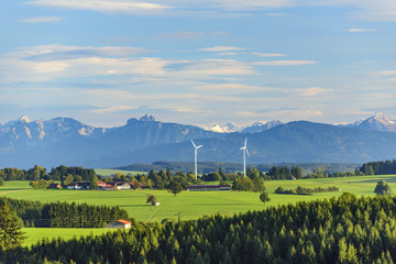 Zwei Windräder vor Alpenkulisse