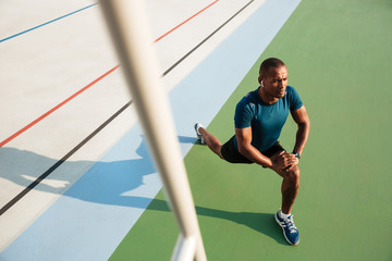 Top view portrait of a young african sportsman doing stretching