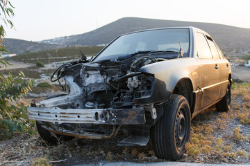 A crashed car in a junk yard 