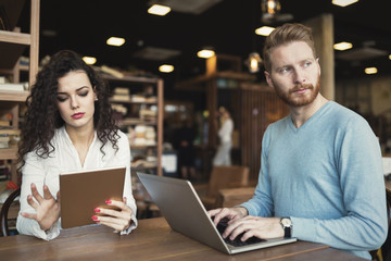 Happy couple spending time at coffee shop working on laptop