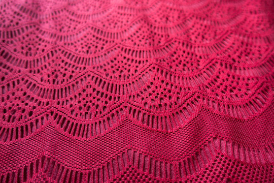 Curvilinear geometric pattern on red lacy fabric
