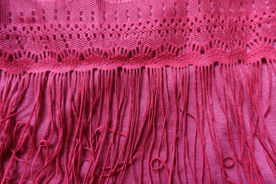 Long fringe on ruby red cotton fabric