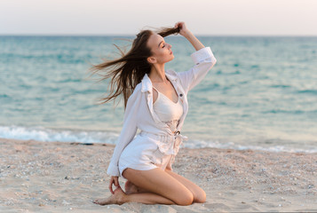 Fototapeta na wymiar Happy carefree woman on the beach enjoying summer