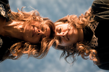 women photographed against blue sky