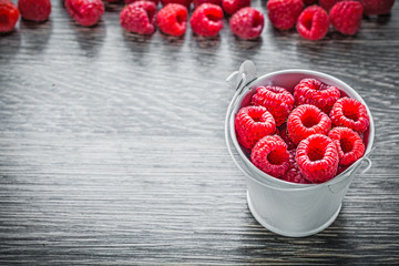 Composition of raspberries in basket on wooden board